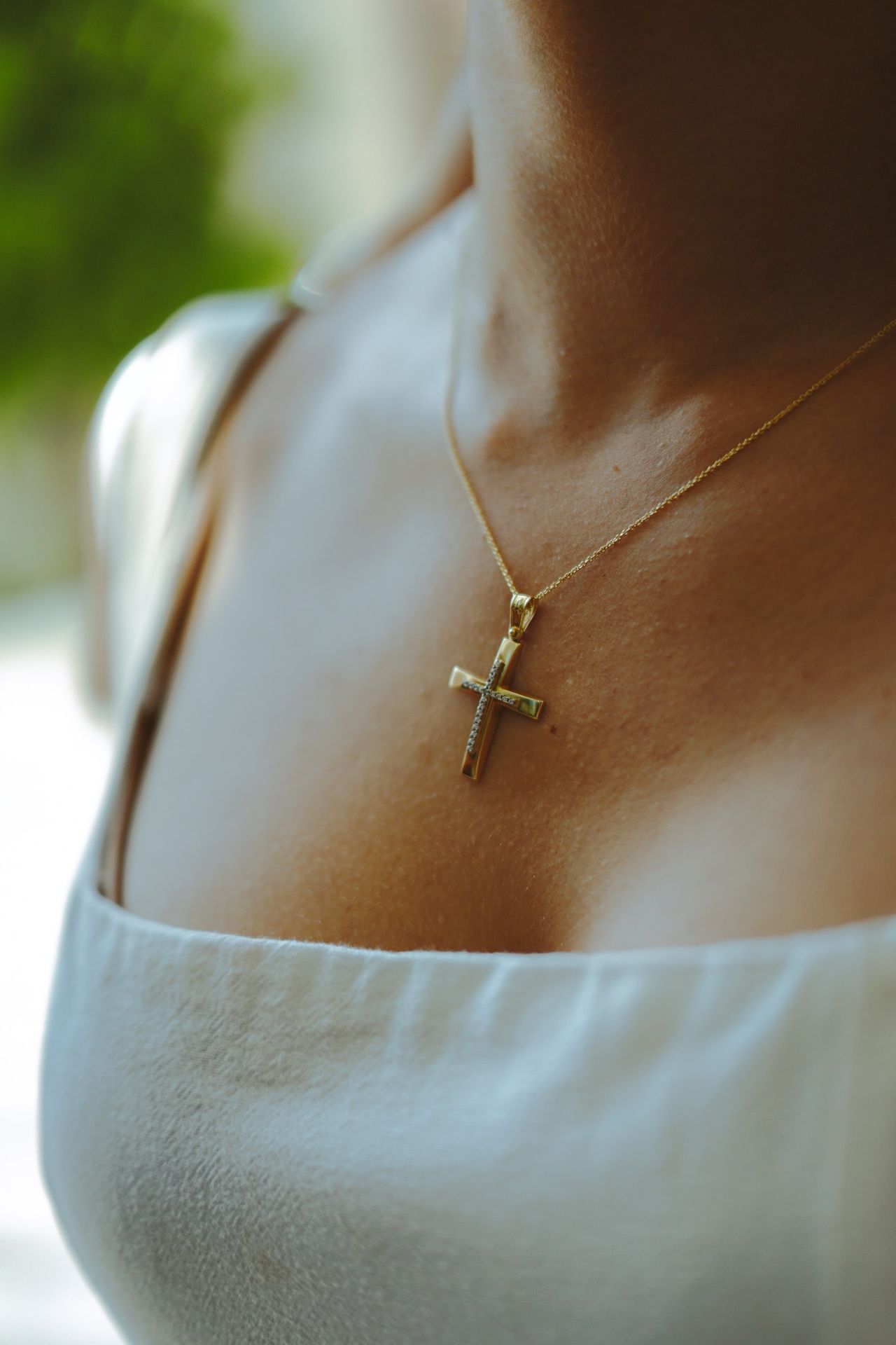 woman wearing silver cross pendant necklace
